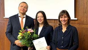 Ines Mullaj mit Urkunde, neben ihr Prof. Bustamante und Prof. Stiller