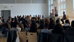 Studierende sitzen in der Aula