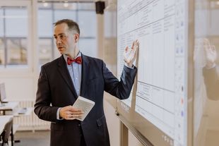 Prof. Schramm erklärt an Whiteboard