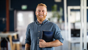 Mann mit Laptoptasche im Arm